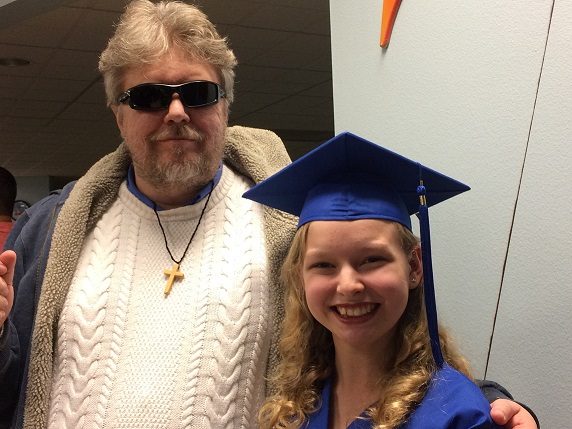 Dan smiles next to his daughter, Sarah, at her graduation.