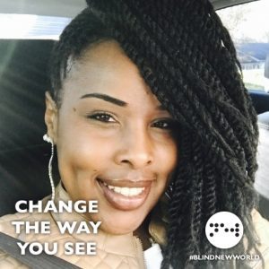 An African American woman with braids smiles in a selfie, sitting in a car. At the bottom of the image, the left side reads "CHANGE THE WAY YOU SEE". The BlindNewWorld logo is in the right corner.