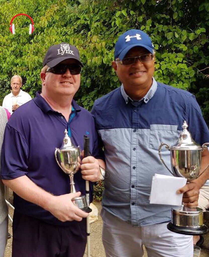 Blind golfer Roger Cole and his sighted guide Ray Jobsz smile for the camera while holding championship trophies