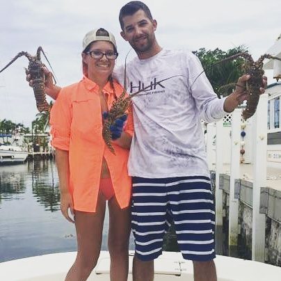 Amanda Lower and husband holding up crustaceans