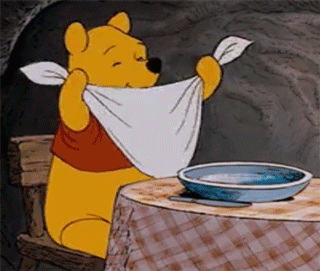 GIF of Winnie the Pooh tying a napkin around his neck.