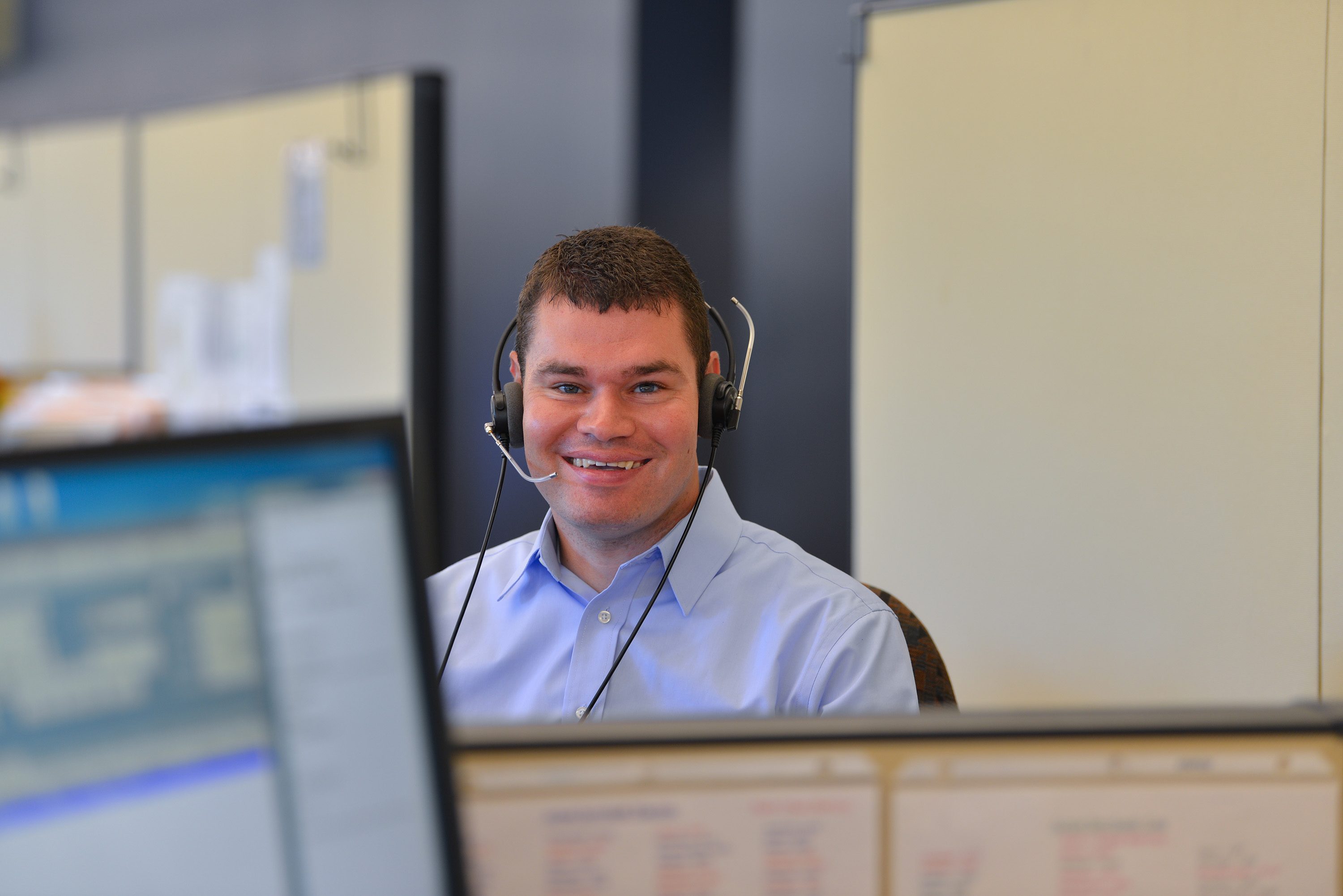 Tim Vernon, wearing a headset and sitting at his desk at work