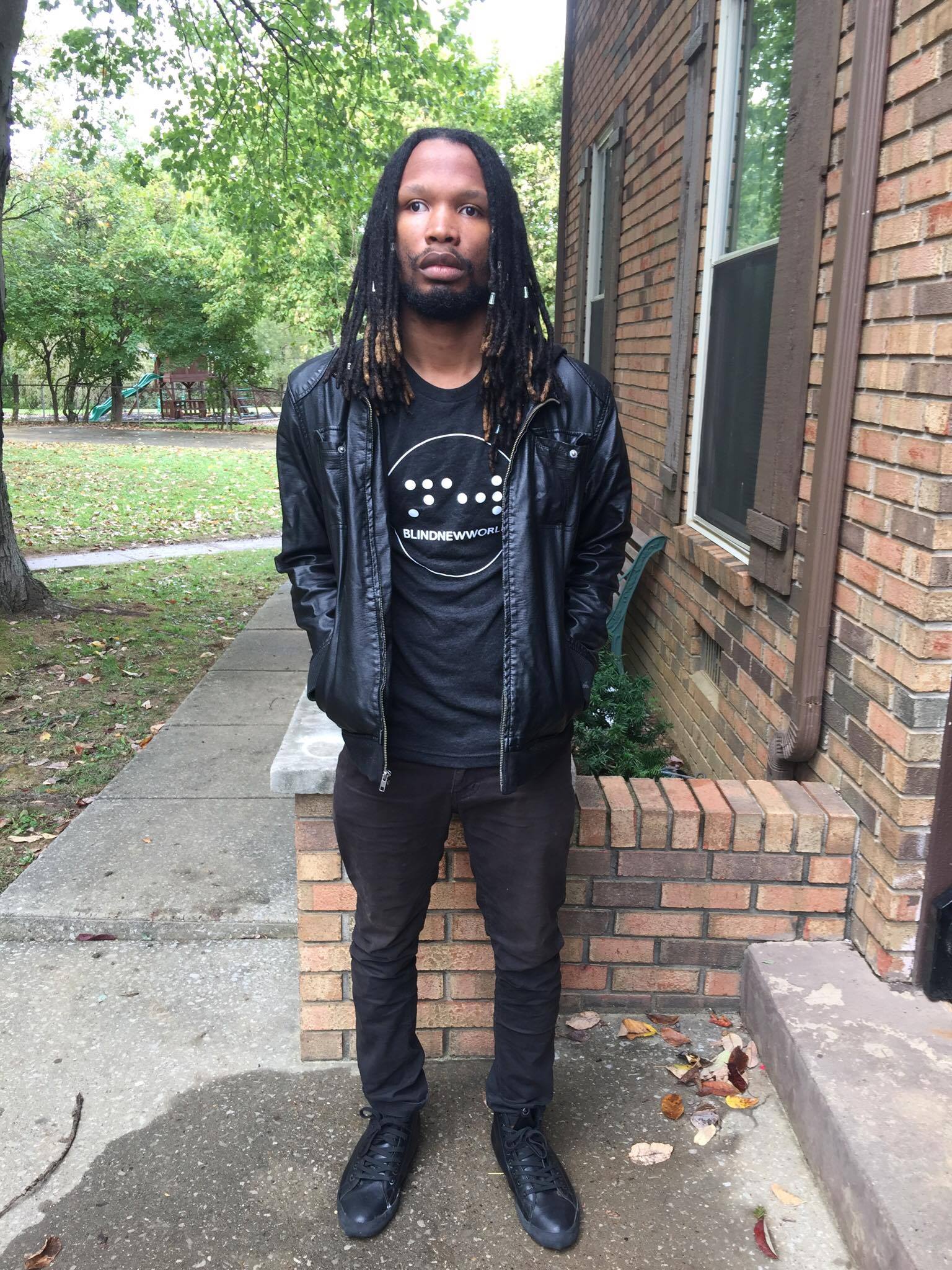 NovoCain, a blind hip-hop artist, wearing a BlindNewWorld t-shirt