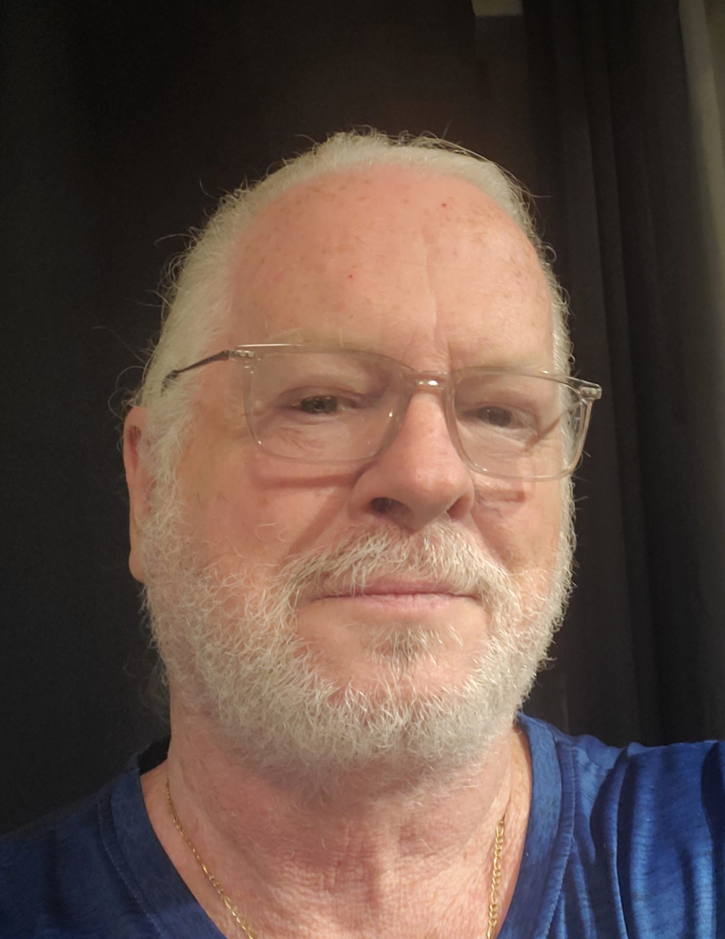 A selfie of David Yerks-Young, a white man with white hair and a white beard wearing glasses, looking serious for the camera