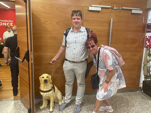 Accessibility consultant Jakob Rosin and his wife Maarja pose for a photo with a guide dog statue